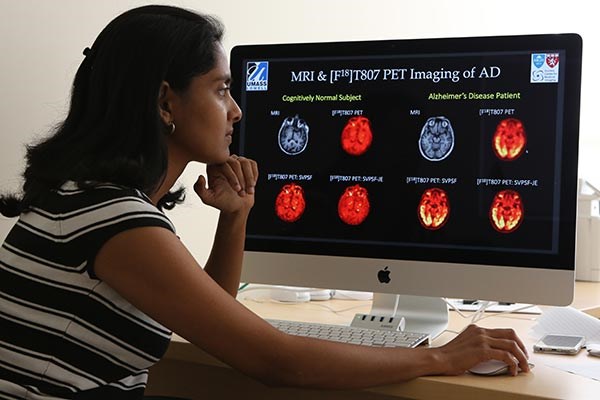 Asst. Prof. Joyita Dutta examines MRI and PET scans.