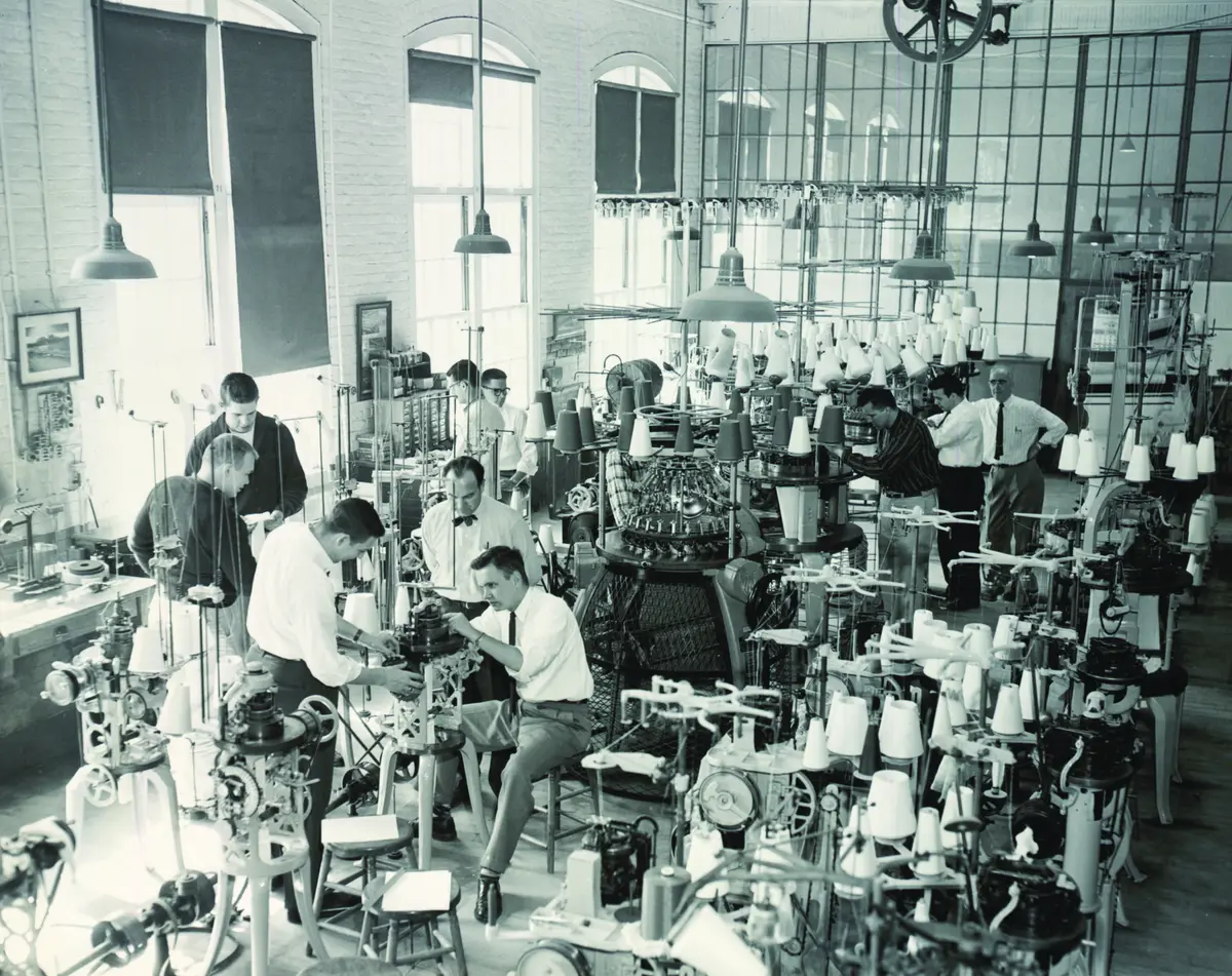 Young men in shirts and ties working in a lab in a black and white photo