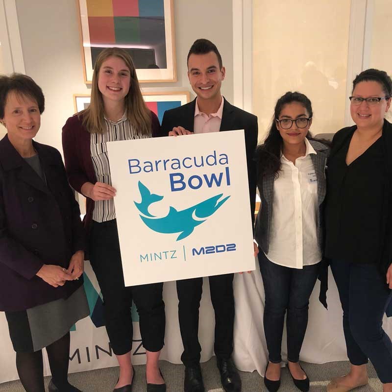 Group of UMass Lowell students holding a "Barracuda Bowl" M2D2 poster.