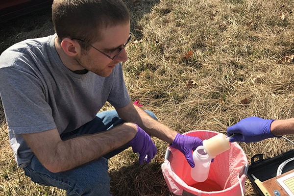 Graduate student Connor Sullivan collects and tests water samples