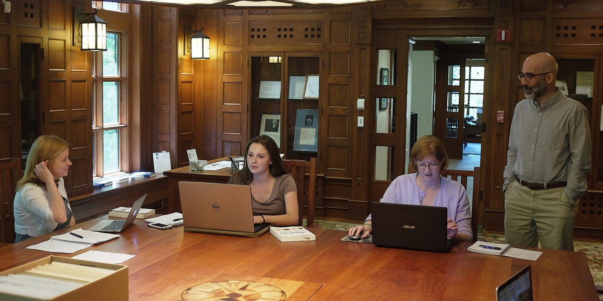 Honors College students Lindsay Blount, Kale Connerty and Erin Monahan work at the Thoreau Institute library with curator Jeffrey S. Cramer.