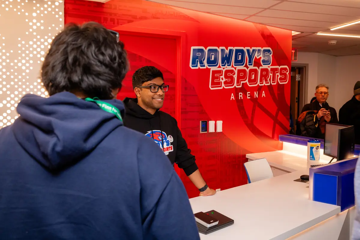 A worker talks to a UMass Lowell student at the sign in desk at Rowdy's E-Sports Arena.