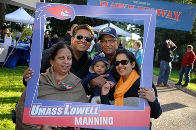 family with instagram photo board that says UMass Lowell Manning School.