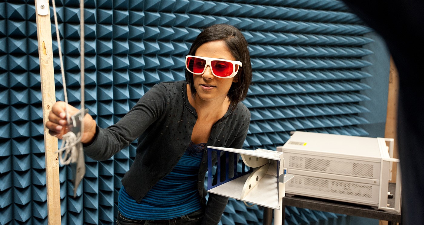 A female UMass Lowell student wearing goggles and working in a Civil & Environmental Engineering lab or class.
