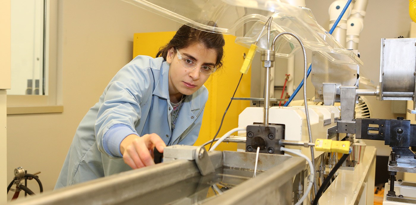 A female UMass Lowell student working in a Plastics recycling lab.
