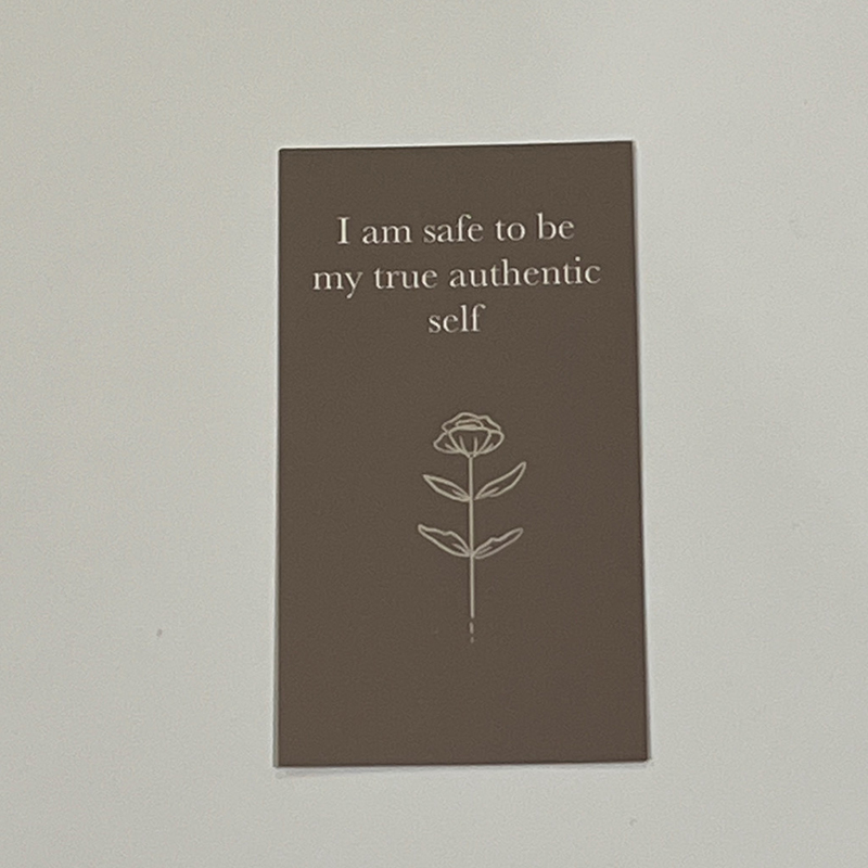 A brown card with a flower on it that says "I am safe to be my true authentic self".
