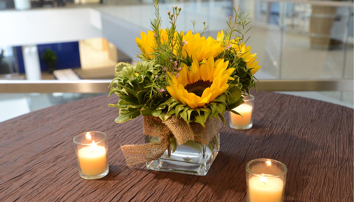 Sunflowers and candles on a table.