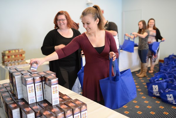 Amanda Hemond helps assemble a Thanksgiving baskets, each filled with canned vegetables, a dessert, a gift certificate to a local supermarket and more for local families in need.