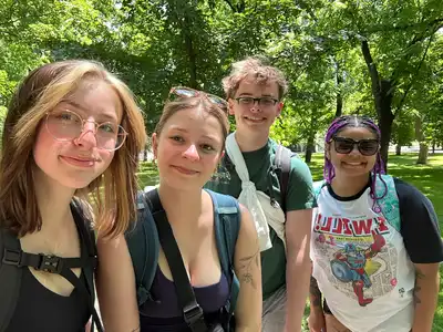 4 UMass Lowell study abroad students pose in a park in San Sebastian, Spain.