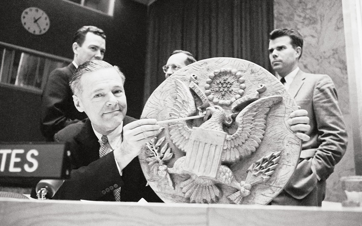 In 1960, U.S. Representative to the United Nations Henry Cabot Lodge Jr. points to the spot on the U.S. Great Seal (a 1945 gift from the Soviets that hung in Spaso House for decades) where it had been bugged, providing proof of Soviet espionage to the U.N. Security Council. The Theremin device inside was activated by external electromagnetic signals, making it difficult to detect.