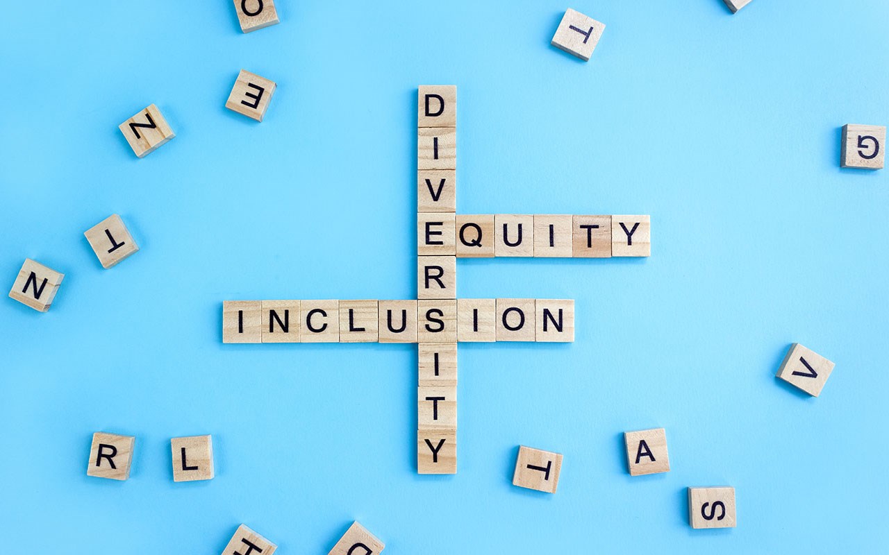 Scrabble board with the words diversity, equity and inclusion written out