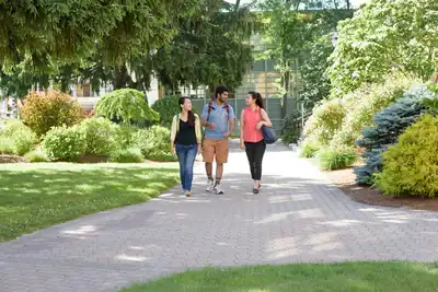 Three graduate students walk and chat together on North Campus