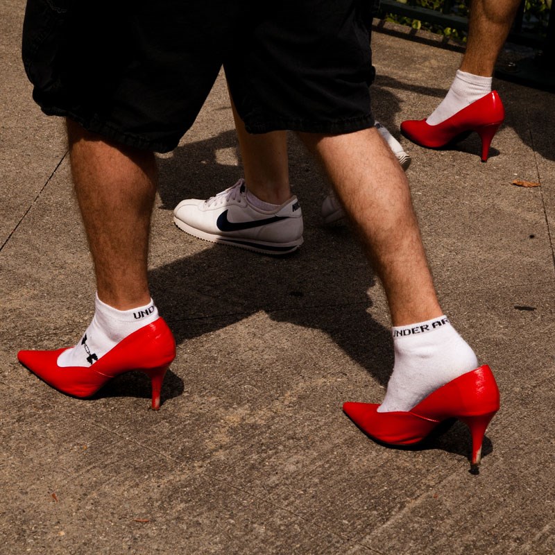 Closeup of male feet walking in red high heels