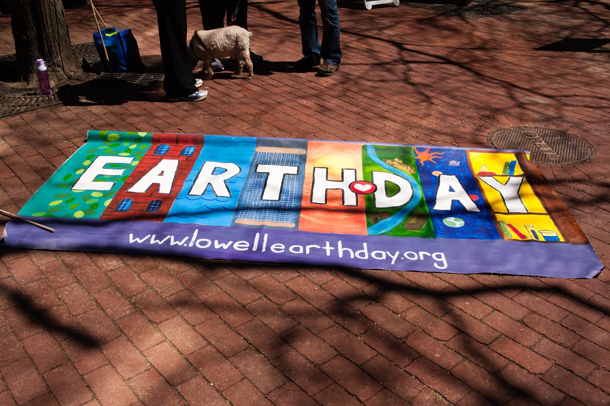 A colorful sign that reads "Earth Day" is exposed on the street during the Lowell Earth Day festivities.