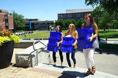 Three female UMass Lowell students carrying blue recycling bins. The UMass Lowell Sustainability team along with our partner Mill City Grows is conducting a Community Supported Agriculture (CSA) program to provide the UMass Lowell community with locally grown, farm fresh produce to promote sustainable urban agriculture and ensure community well-being.