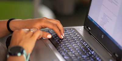 woman's hands on laptop keyboard