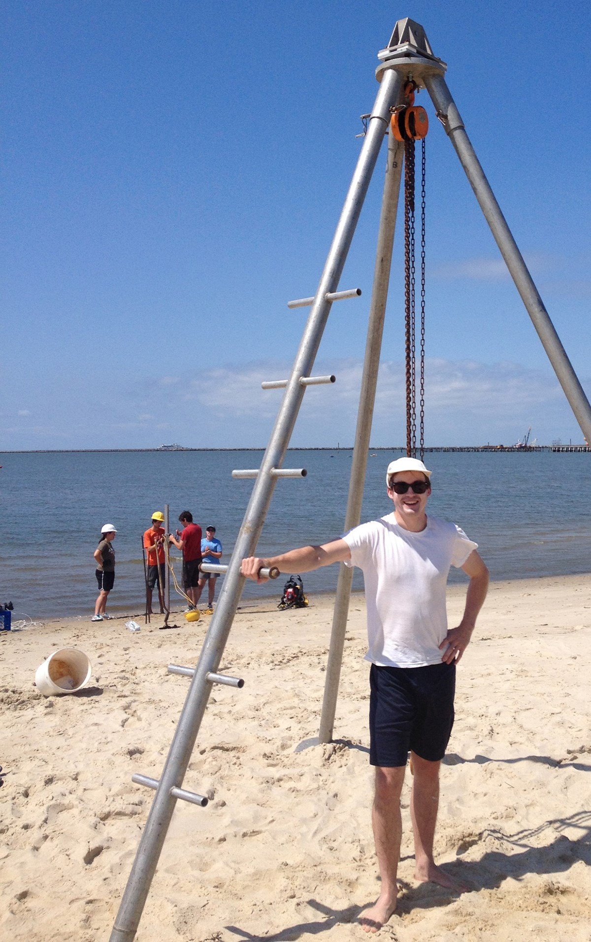 Assistant Professor James Heiss poses next to equipment at a beach. Heiss' research area is coastal groundwater dynamics and nutrient cycling in nearshore aquifers. I am interested in the influence of land-sea processes (tides, sea level rise, terrestrial recharge) on the exchange of water and chemicals between groundwater and surface water in estuarine, beach, bay, marsh, and marine environments. This work has direct implications for groundwater resources and water quality of coastal systems.