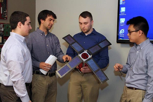 UMass Lowell students Charles Barbon, Jacob Hulme, William Mann and Dat Le are building a satellite that space agency NASA hopes to launch in 2018.