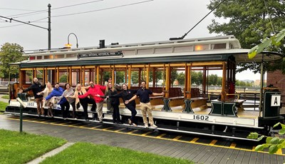 UMass Lowell Hospitality & Event Services staff pose on a Lowell trolley.