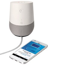 Google Home device pictured alongside with a smartphone displaying the Google Home app