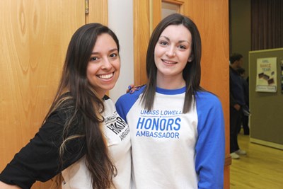 Two female honors ambassadors smile wearing matching baseball t-shirts during a welcome day event