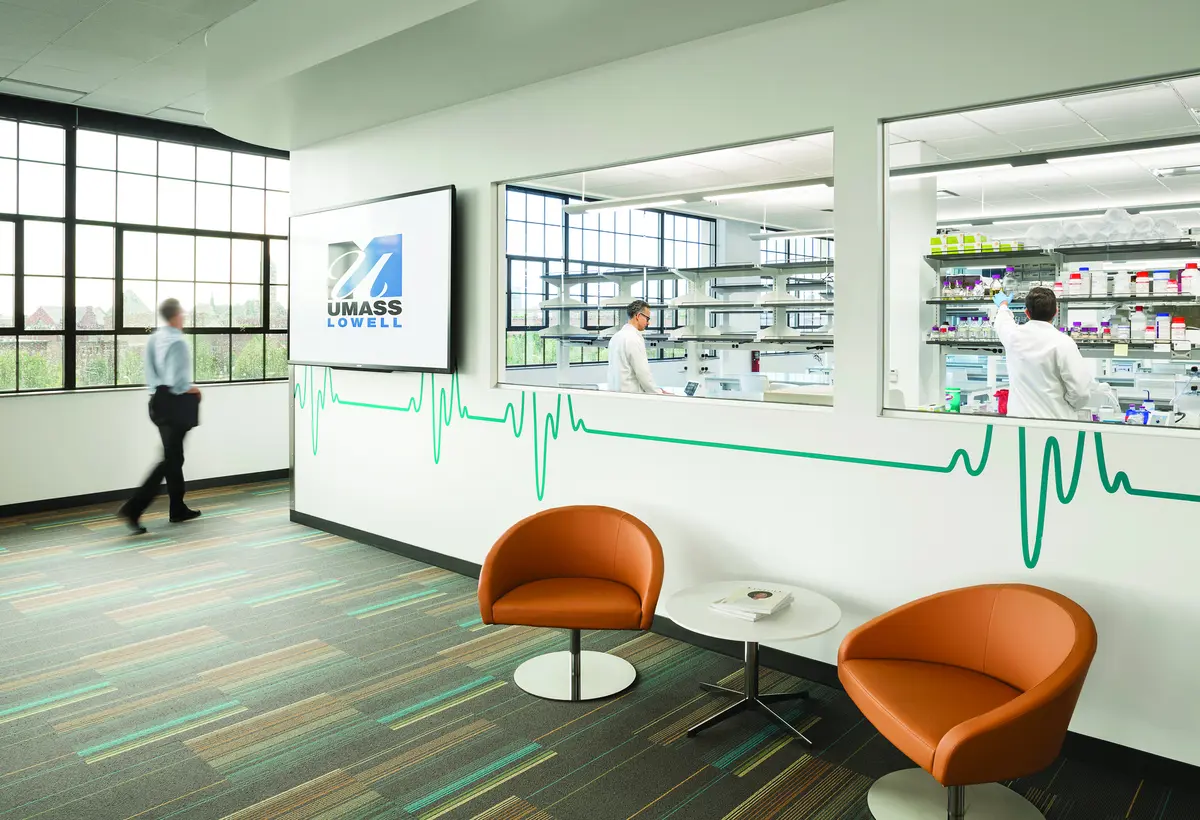 Lobby of 110 Canal building with UMass Lowell logo on wall