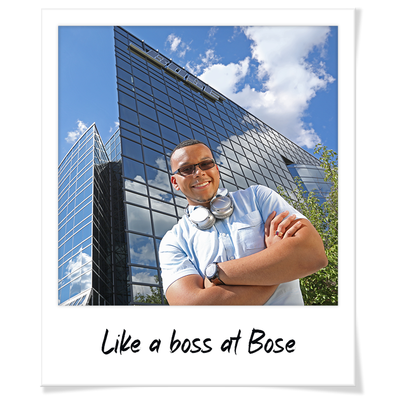 "Polaroid" headshot of Jack Goutier standing outside the Bose global headquarters in Framingham with headphones around his neck - handwriting on photo frame reads "Like a boss at Bose"