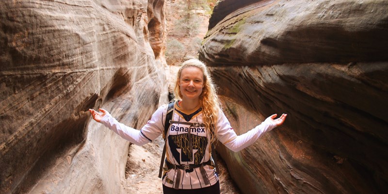 Jennifer Schultz posing during a hike between two large red rocks