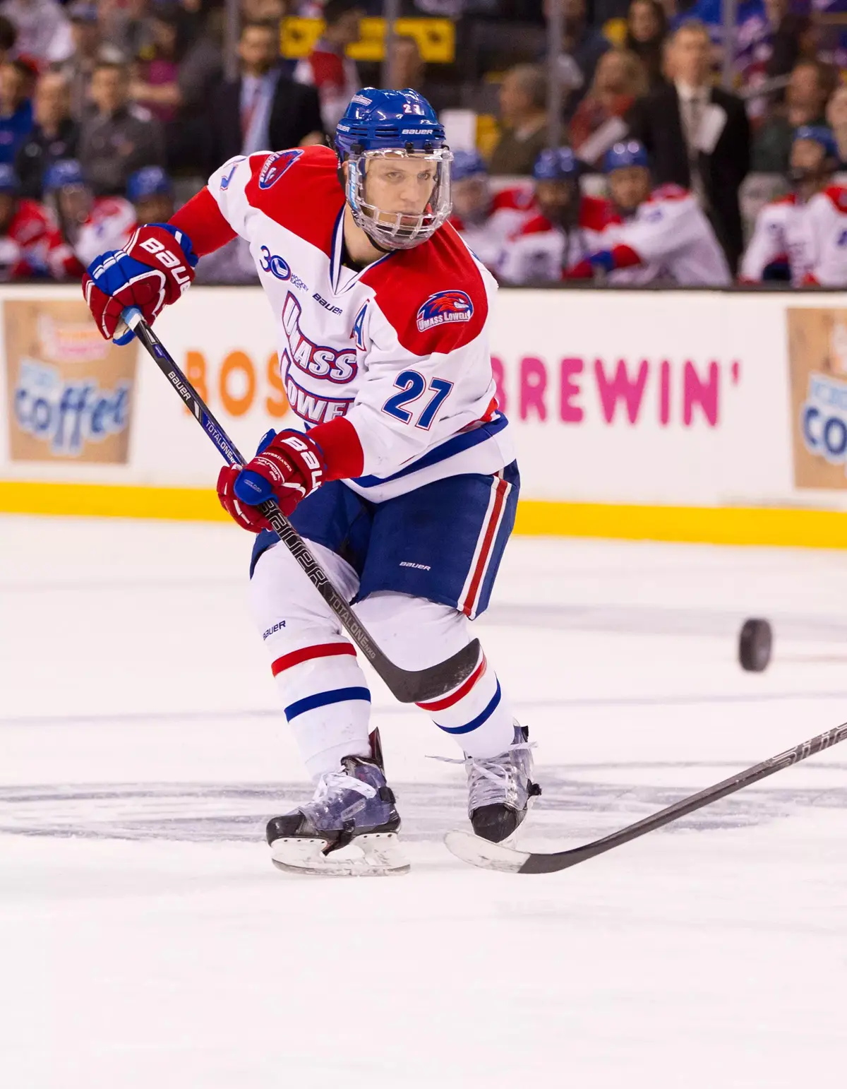 A college hockey player on the ice during a game.