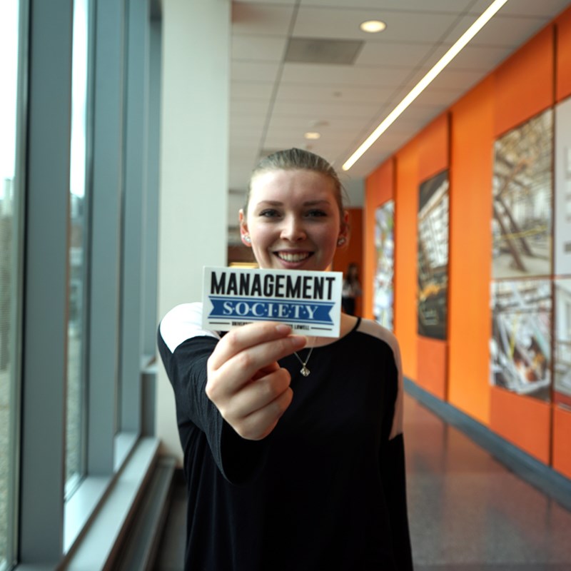 Kelly Bradford holds a Management Society sticker in the Pulichino Tong Business Center