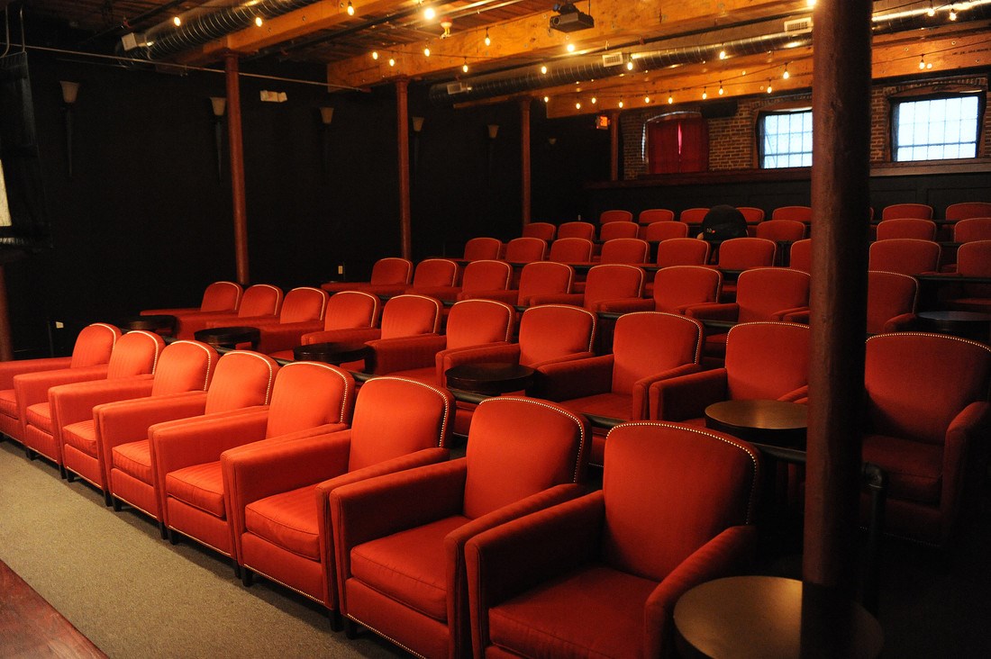 Rows of plush red seats inside the Luna Theater in Lowell