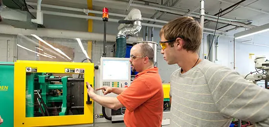 Student learns to operate plastics engineering lab equipment at UMass Lowell.