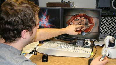 male-student-pointing-at-model-on-computer-screen