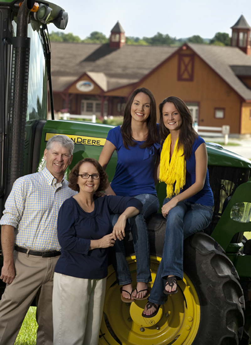 Mark Parlee and his family stand in front of a tractor at Parlee Farms