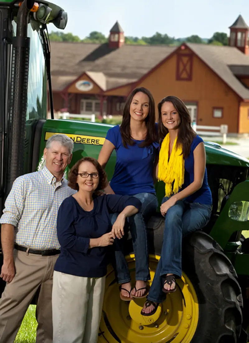 Mark Parlee and his family stand in front of a tractor at Parlee Farms