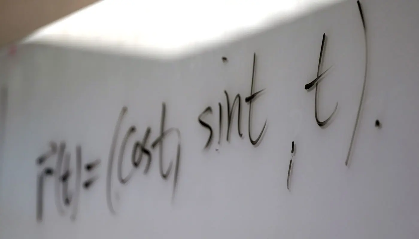 Math formula written on a whiteboard.