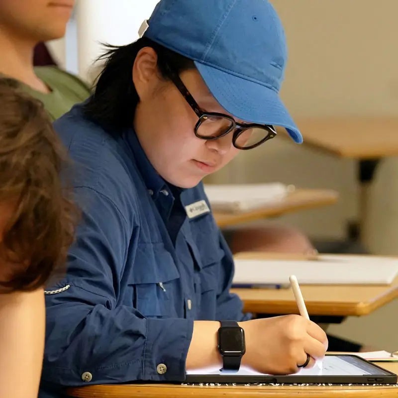 UMass Lowell math student writes on a tablet device.