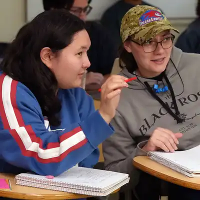 Two students discuss math in a UMass Lowell classroom.