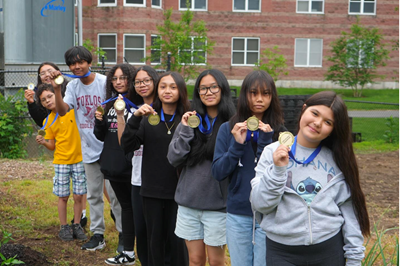 Stoklosa School students holding up medals worn around their necks.