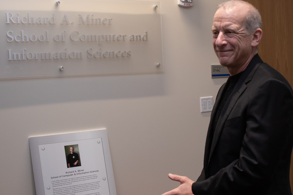 Richard Miner in front of the sign bearing his name