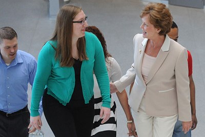 UMass Lowell Chancellor Jacquie Moloney speaks with a student as she walks up the stairs