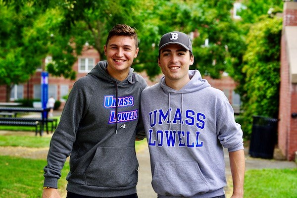Two male students in UMass Lowell sweatshirts pose for a photo
