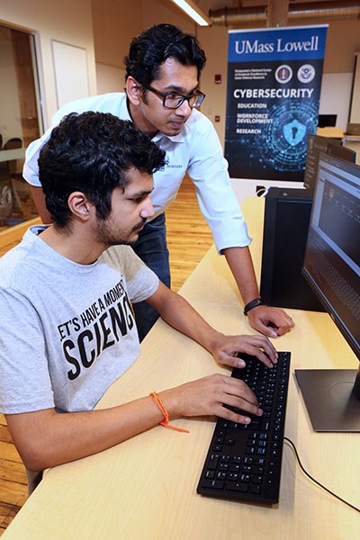Sashank Narain, standing, and graduate student Rakshith Singh run a test