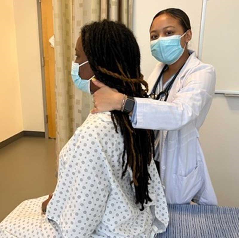 A nursing student examines a patient's neck