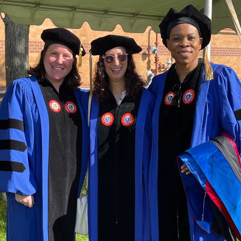 Three students from UMass Lowell's Ph.D. in Nursing program pose in their regalia