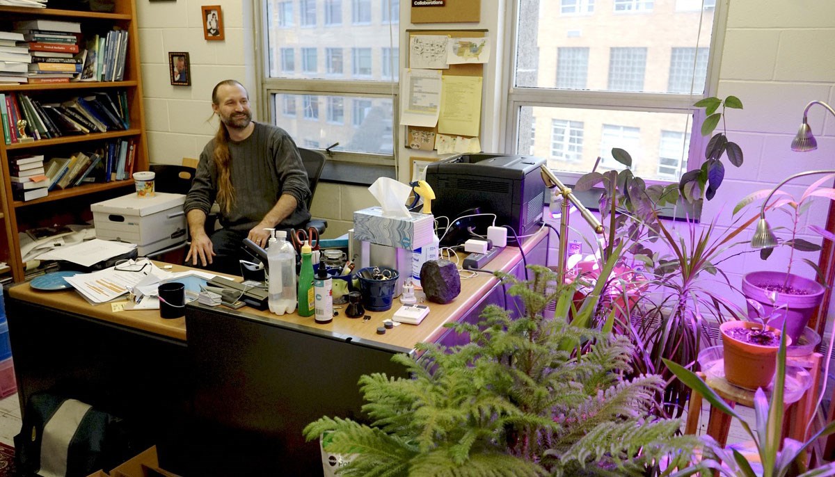 Mathew Barlow surrounded by plants in his office
