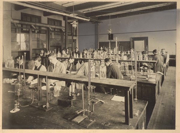 Male students work in a chemistry lab in the early 1900s.