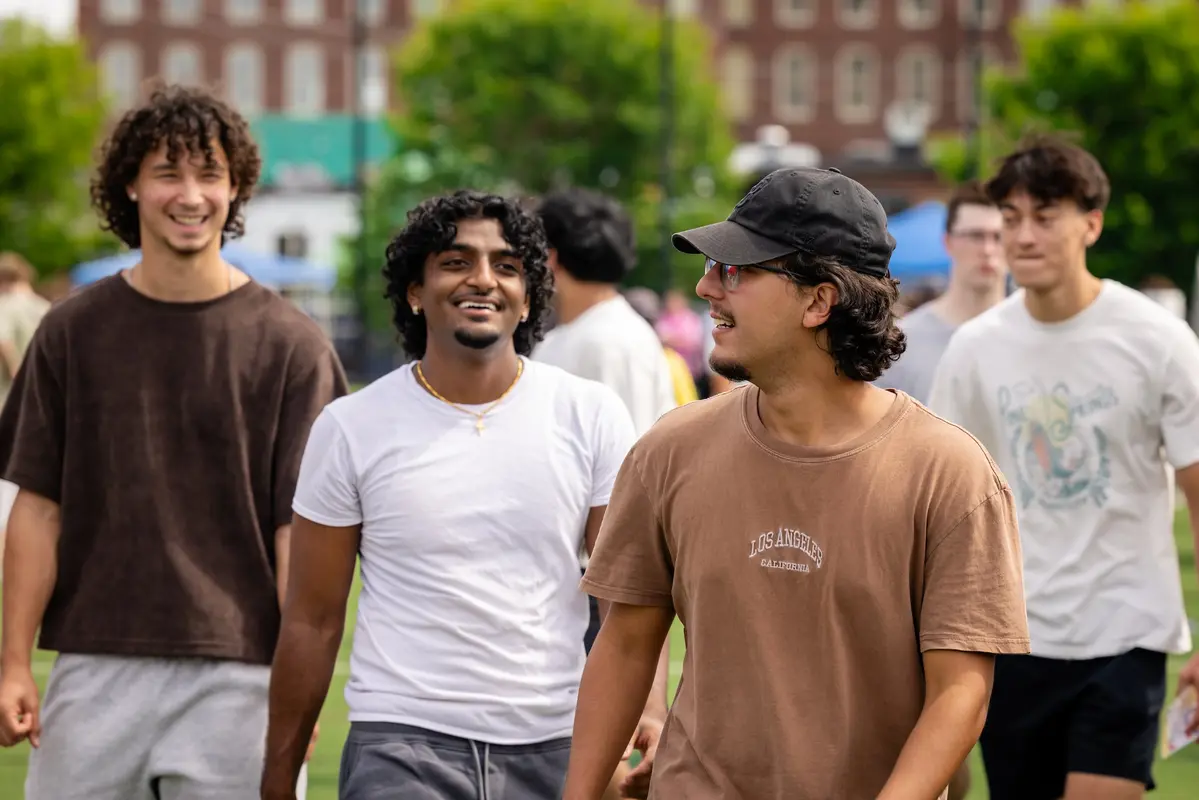 A group of students walk around outside enjoying the Engagement Fair.