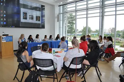 Several students listening to a panel of industry professionals discussing success in engineering.