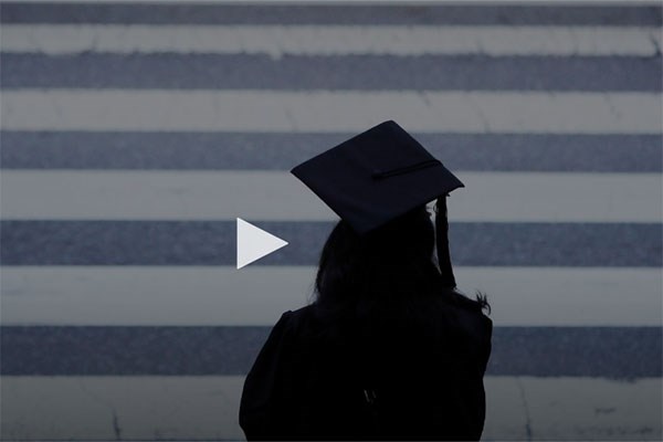 Silhouette of graduate in front of black and white stripes